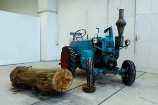 Der blaue Traktor (mit Knüppel), 2011, hist. Traktor, Holzstamm, Baumscheibe, Ketten, Schluppe, Bauklammern, ca. 2x3x4 m && the blue tractor (with log), 2011, old Lanz Bulldog tractor, log, tree pit, heavy chain, belts, steel brackets, ca. 2x3x4 m